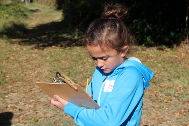 Child outdoors with clipboard